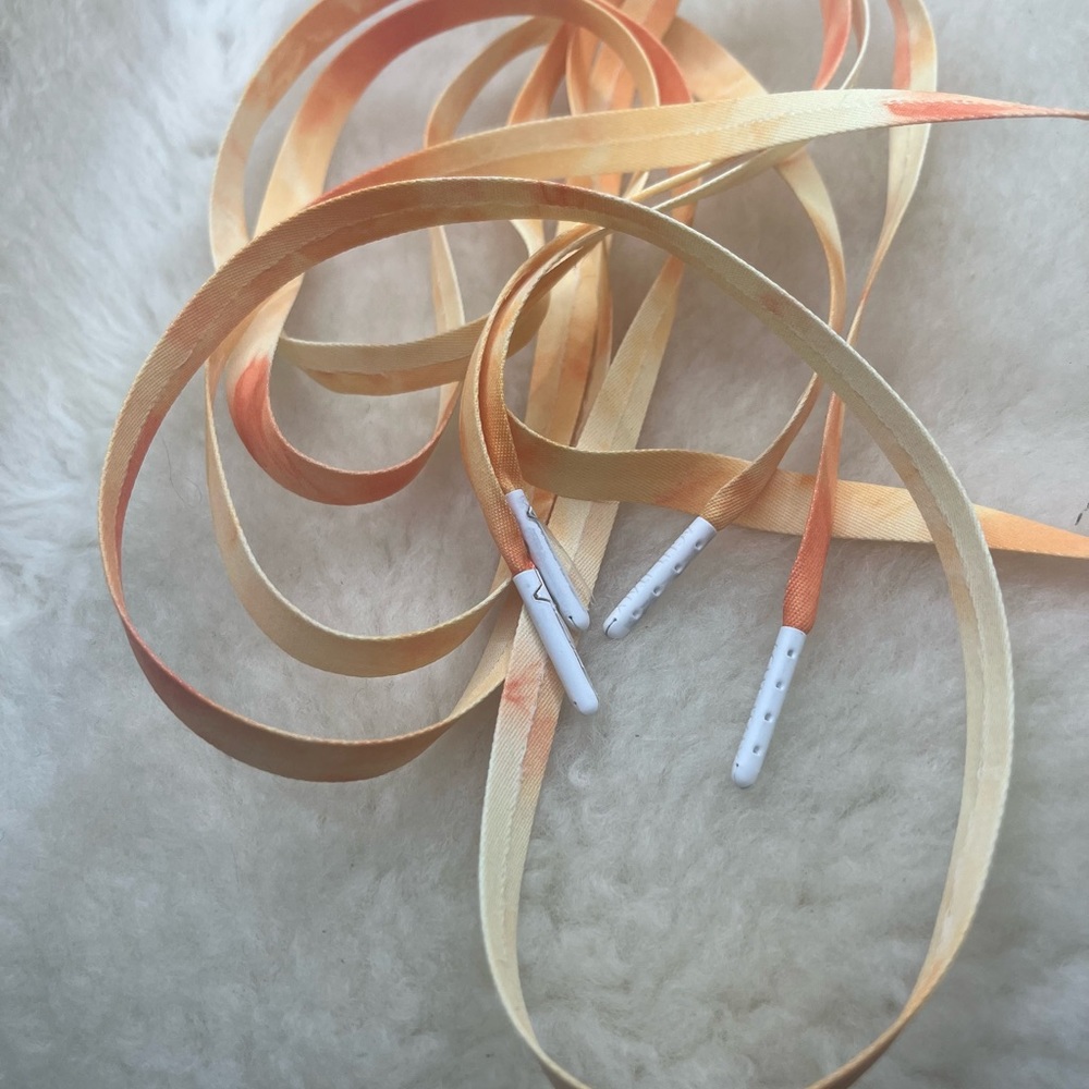 A pair of tied-dyed shoelaces with a matte finish white tips